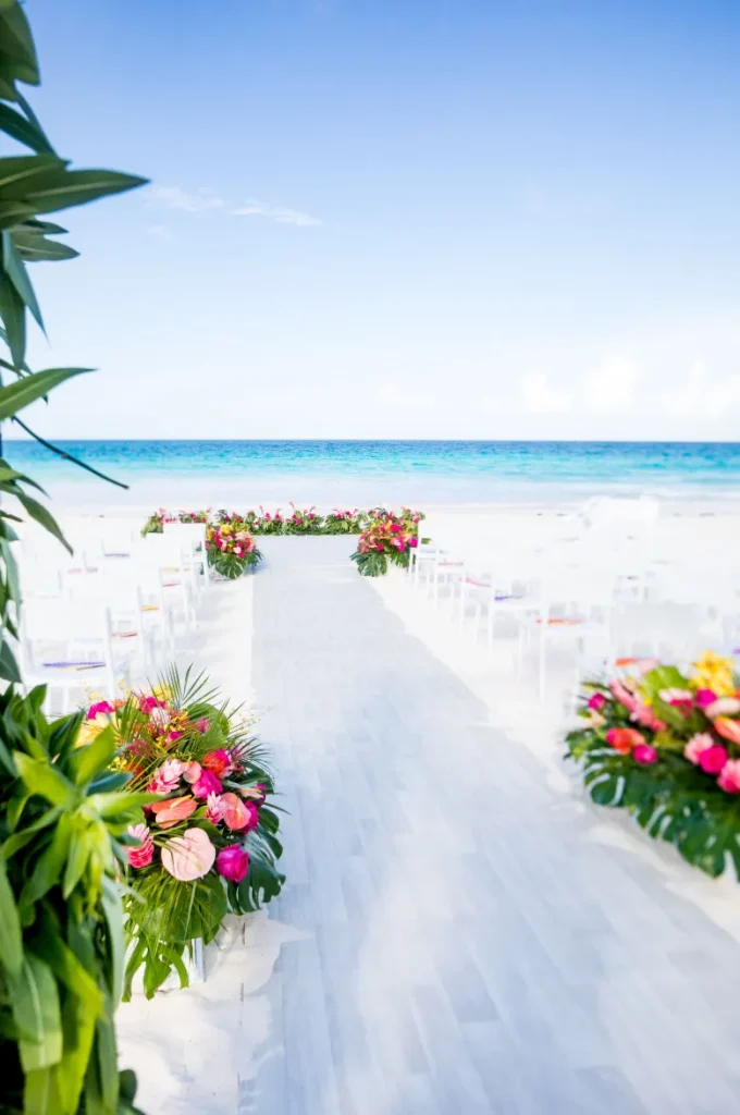 wedding ceremony site on a white sand beach with tropical foliage